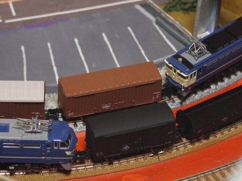 段ボールレイアウト上のEF66形電気機関車、ワラ1形貨車、トラ70000形貨車とEF65-1000形電気機関車とワム80000形貨車の画像