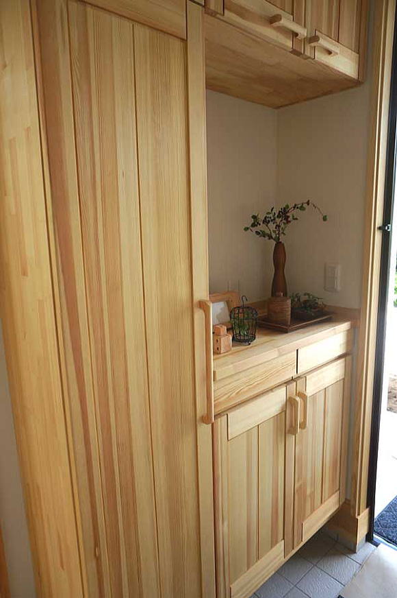 赤松材の天然木の玄関収納はオリジナル。内部は桐材を使用しているので、靴の嫌な臭いや湿気を吸収してくれて、気の香りがする玄関ホールは来客時にも匂いの心配はいりません