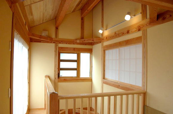 ２階吹き抜け部分の手すり。右の障子戸は寝室。傾斜天井でのびのび空間