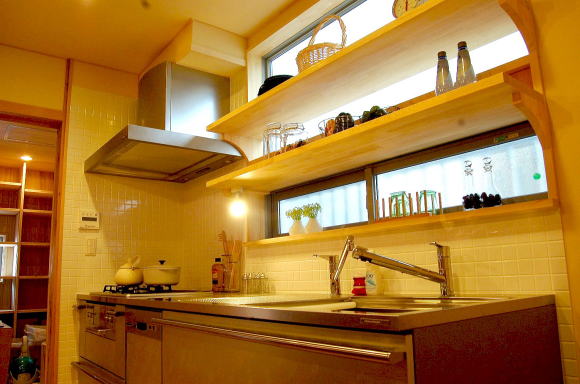 キッチンには大きめの窓を付け、無垢材の棚板を